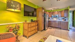 A modern kitchen with wooden cabinets, a built-in microwave, and a large island with a refrigerator. - AVAILABLE IRONMAN 2026 - OCEANVIEW Brilliant condo Close to the PIER For Ironman (Kailua-Kona)
