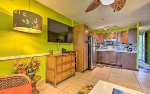 A modern kitchen with wooden cabinets, a built-in microwave, and a large island with a refrigerator. - AVAILABLE IRONMAN 2026 - OCEANVIEW Brilliant condo Close to the PIER For Ironman (Kailua-Kona)