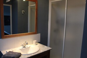 A bathroom with a white sink, a mirror with a wooden frame, and a shower area. - Logement avec 3 suites parentales,proche Mémorial de Vimy, Lens, Liévin, Arras (Givenchy-en-Gohelle)