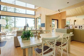 A spacious room with a large dining table, chairs, and a view of the outdoors. - Chalet with hot tub above the Champagne vineyards (Cormoyeux)