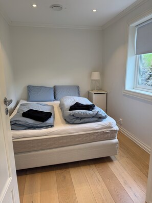 A bedroom with a bed, pillows, a bedside lamp, and a window. - Luxury 2-bedroom apartment in charming Vestland perfect for relaxing stay (Vestland)