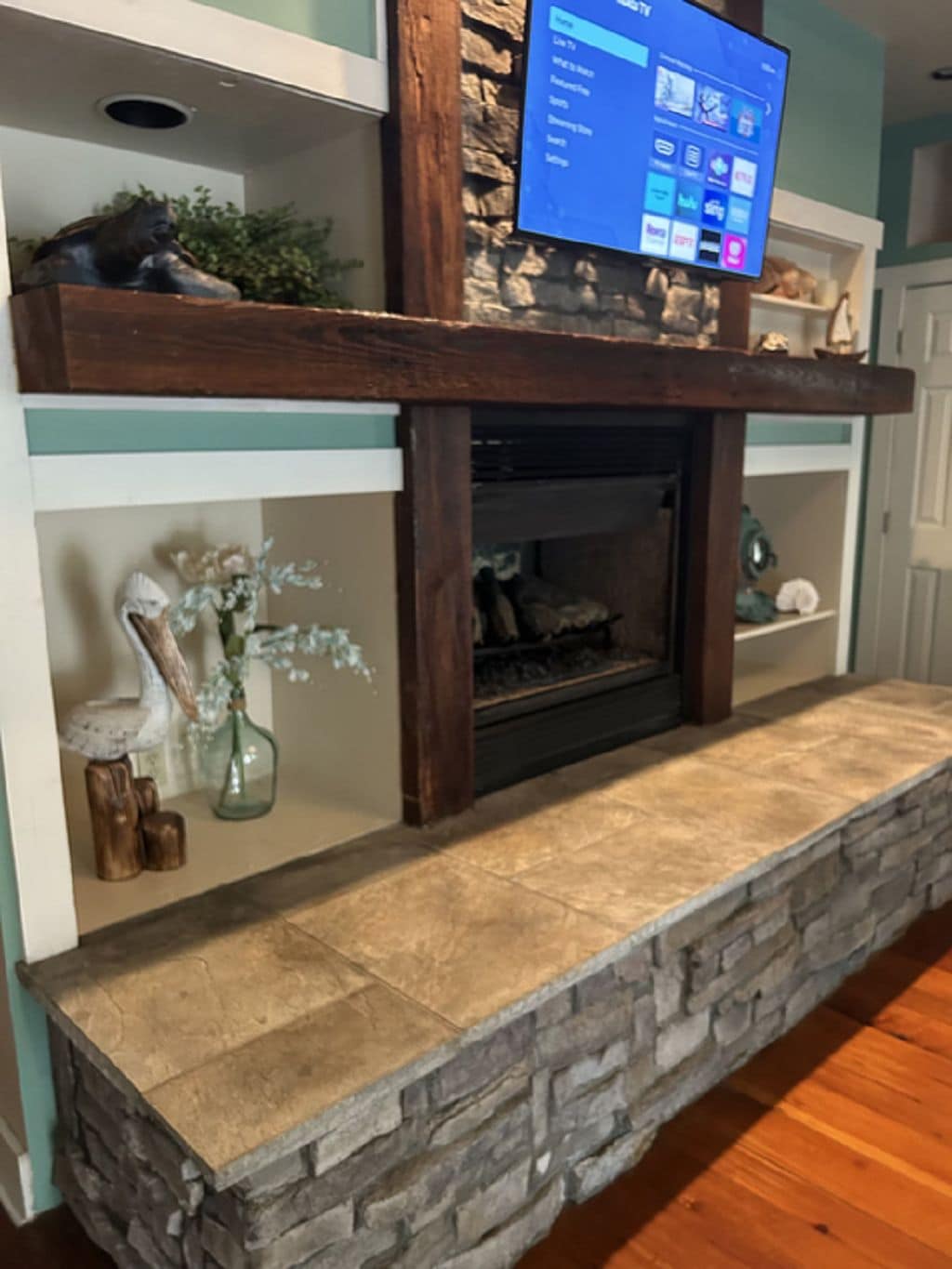 A stone fireplace with a TV mounted above it.