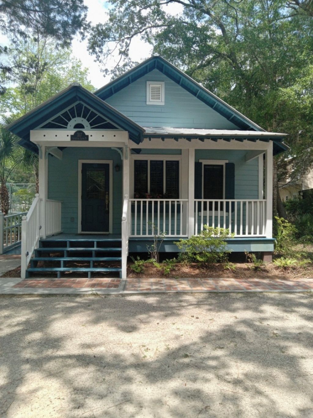 A two-story house with a porch, a front door, and a small front yard.
