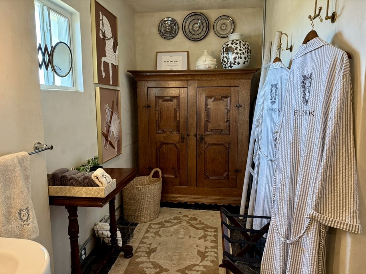 A bathroom with a wooden cabinet, a towel rack, and a rug.