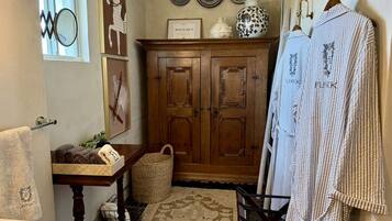 A bathroom with a wooden cabinet, a towel rack, and a rug.