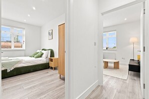 Une chambre à coucher moderne, avec un lit, une table de chevet et une vue sur l’extérieur.