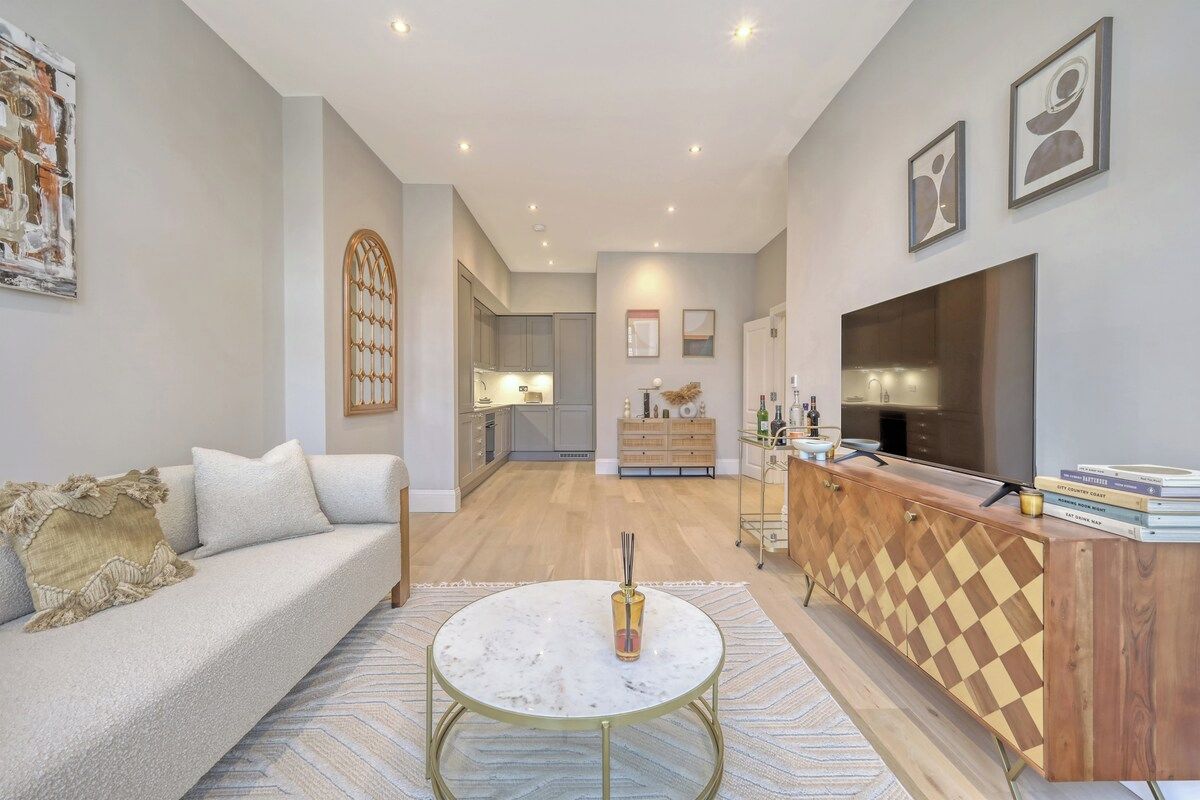 A modern living room with a sofa, a coffee table, a TV, and a wooden cabinet.