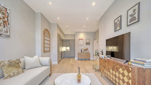 A modern living room with a sofa, a coffee table, a TV, and a wooden cabinet. - Luxury Apartment w/ Modern Kitchen & Free Parking (Southend-on-Sea)