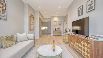 A modern living room with a sofa, a coffee table, a TV, and a wooden cabinet.