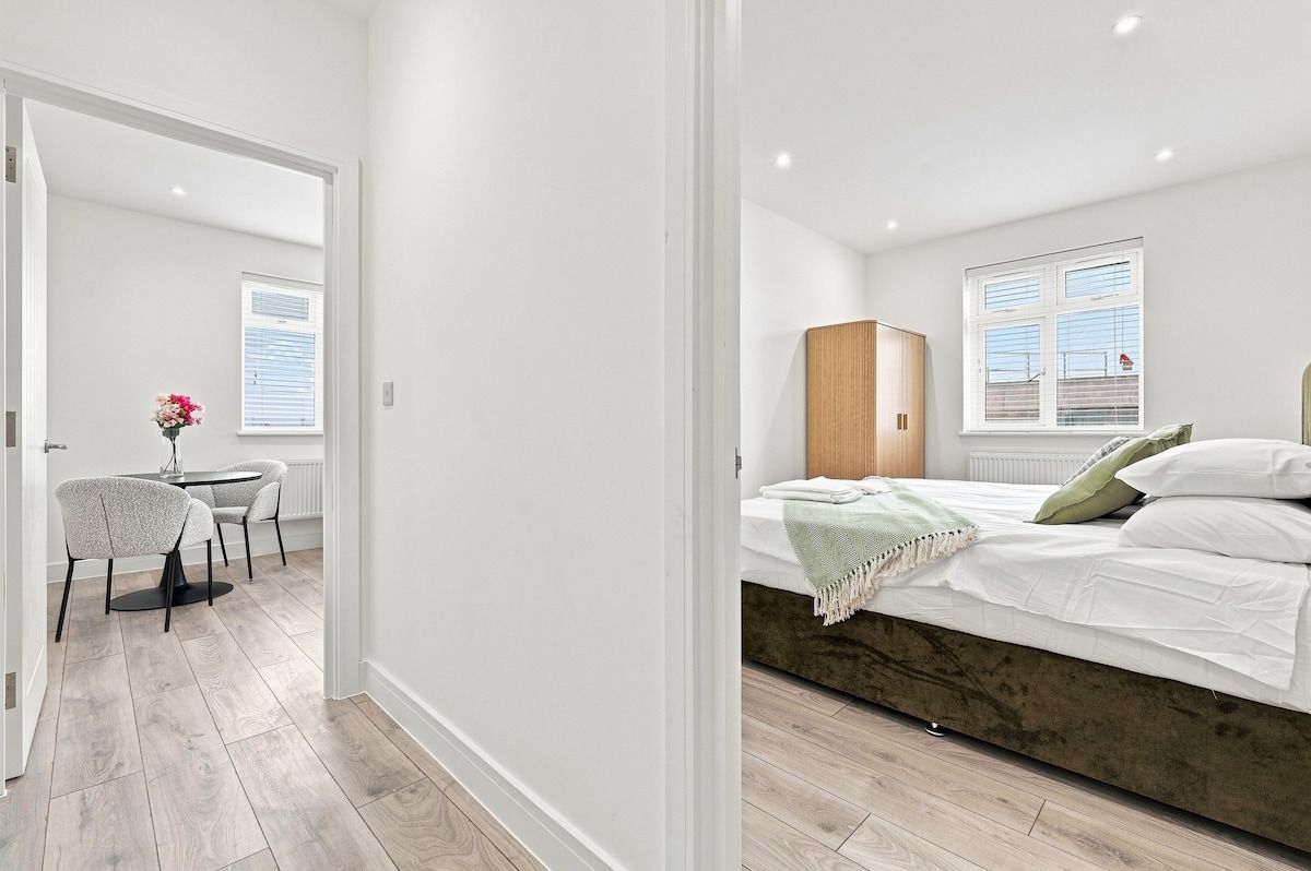 Une chambre à coucher moderne avec un lit, une table de chevet et une fenêtre.