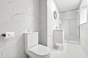 A modern bathroom with a toilet, bidet, and glass-enclosed shower. - Brand New 1-Bed,  Ilford Lane, Near Station (Greater London)