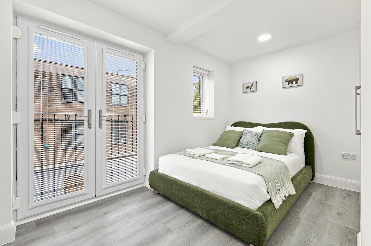 Une chambre à coucher avec un lit, une fenêtre et une porte équipée de stores.