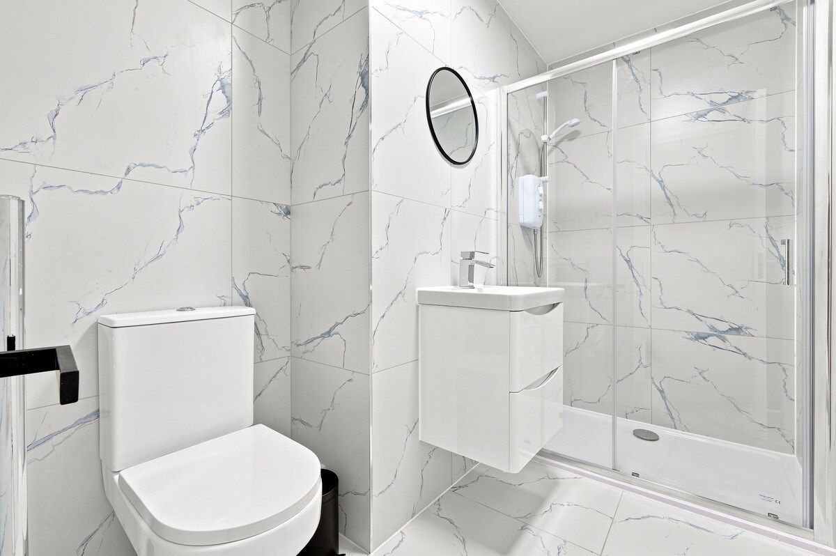 Ein modernes Badezimmer mit Toilette, Waschbecken und einer Duschkabine.