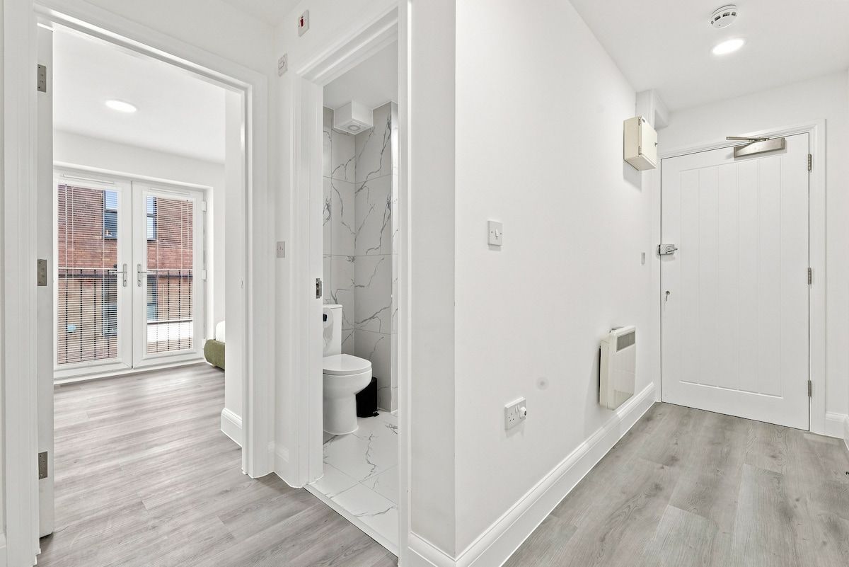 Une salle de bain moderne avec des toilettes, une douche et des murs blancs.