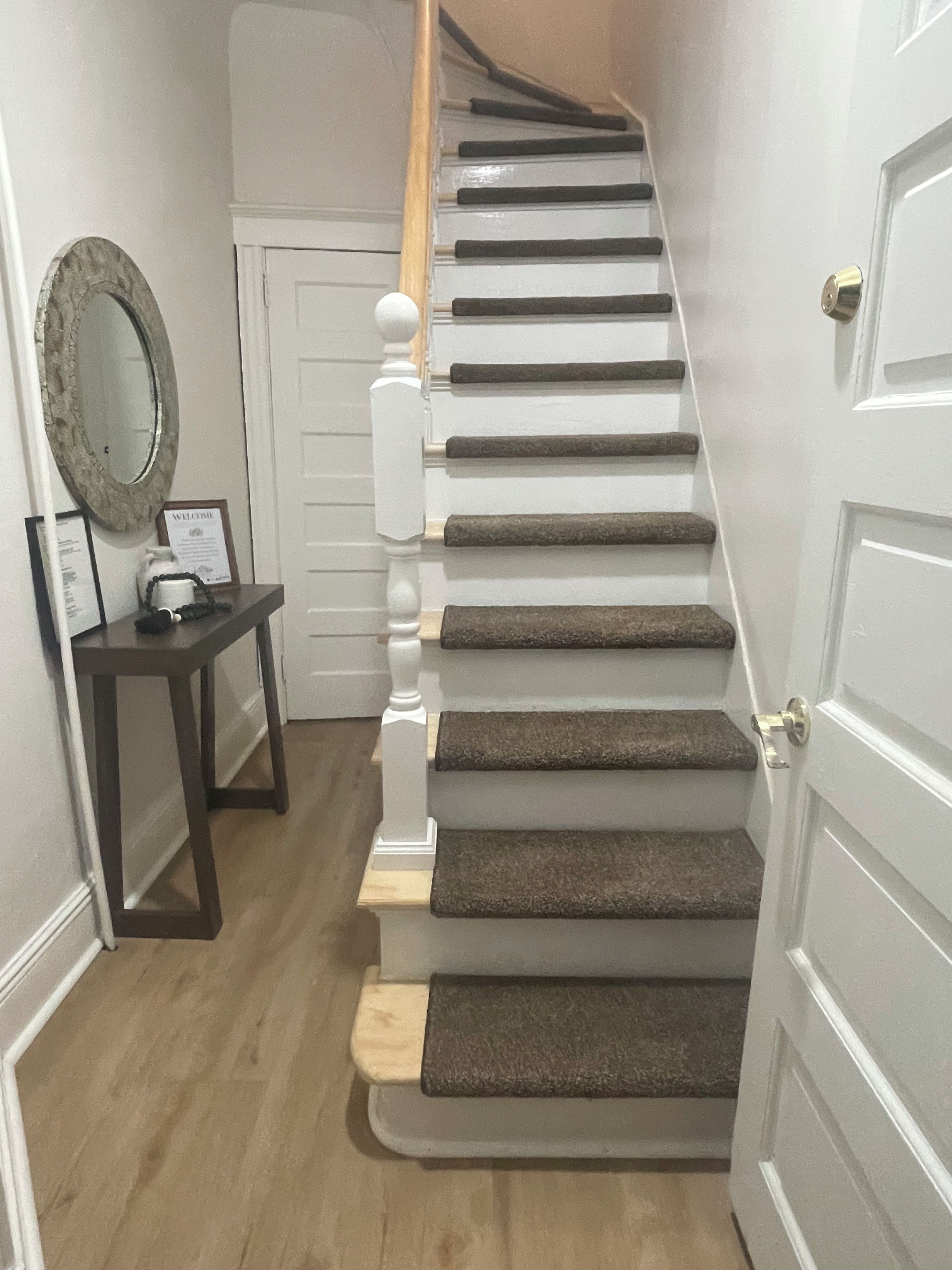 A staircase with wooden steps and a white door at the top.