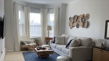 A living room with a sofa, coffee table, and decorative wall art.