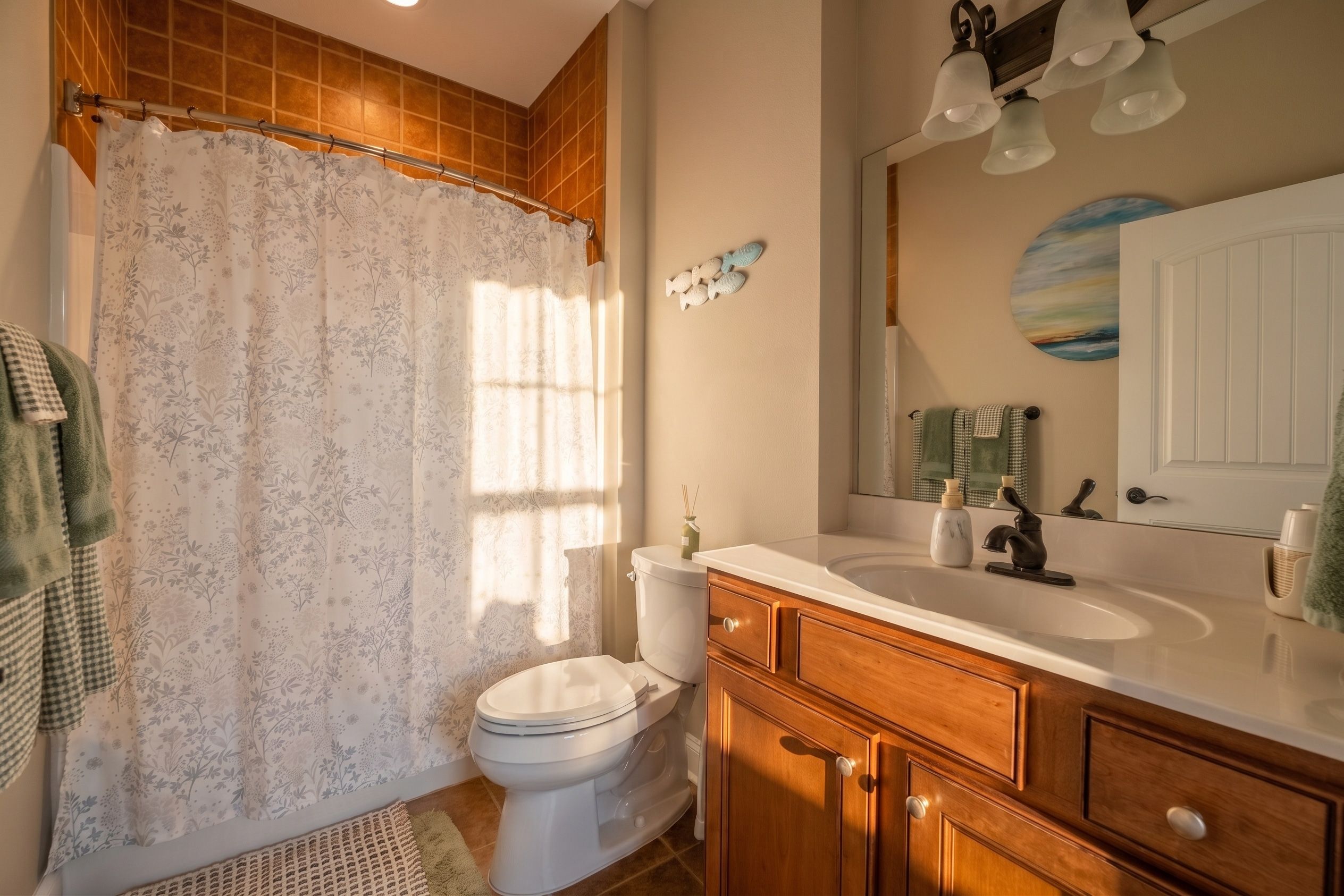 Un baño con inodoro, lavamanos y armario de madera.