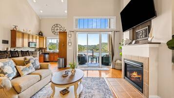 A spacious living area with a fireplace, a dining area, and a kitchen.