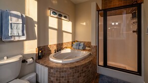 Une salle de bain comprenant une baignoire, des toilettes et un espace douche.