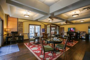 A spacious living room with a fireplace, a dining area with a round table, and a television. - St. Augustine | Old Town Retreat | Pool & Historic Charm (St. Augustine)