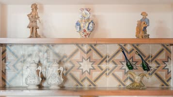 Una mensola con diversi oggetti in ceramica, tra cui una figurina, un vaso e due brocche.
