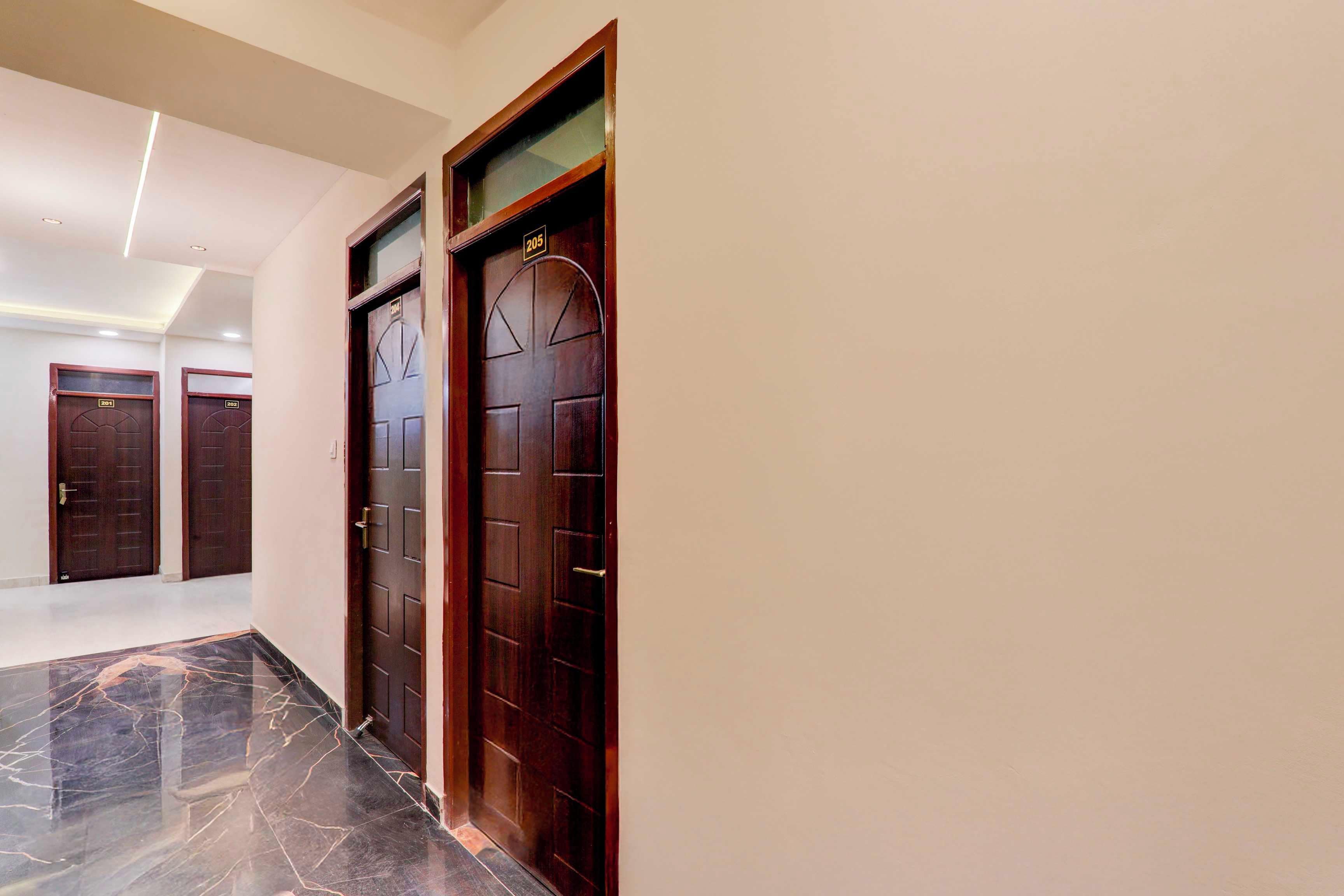 A hallway with three wooden doors, each with a number plate, leading to different rooms.