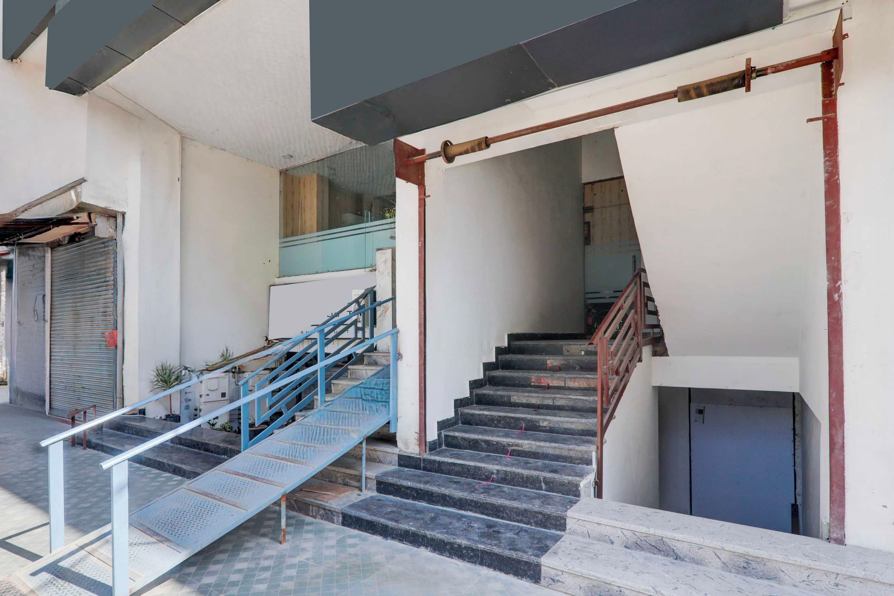 A staircase with metal railings and a handrail, leading to an upper floor.