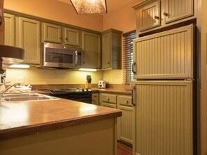 A kitchen with a built-in microwave, stove, and refrigerator. - Big Cedar | Family Lake Escape | Pool & Nature | 2BR Lodge (Ridgedale)