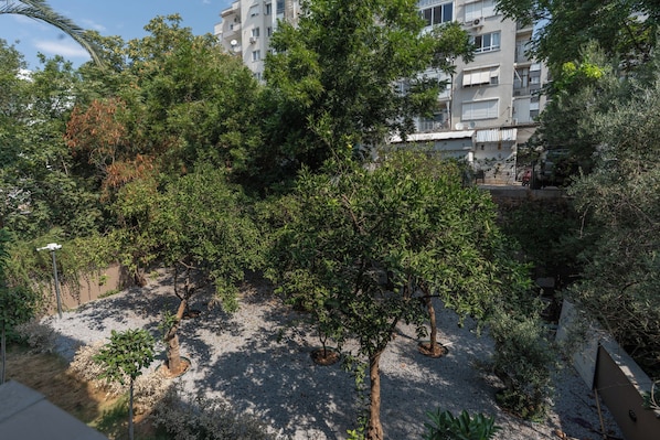 A residential area with multiple apartment buildings, trees, and a gravel pathway.