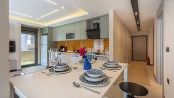 Cocina moderna con comedor, que cuenta con una isla central con una mesa preparada para cuatro personas, un microondas y una estufa.
