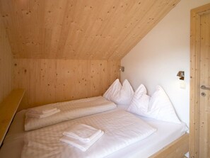 A small, wooden room with two beds, each with white bedding and pillows. - One-bedroom Cabin (Sankt Georgen am Kreischberg)