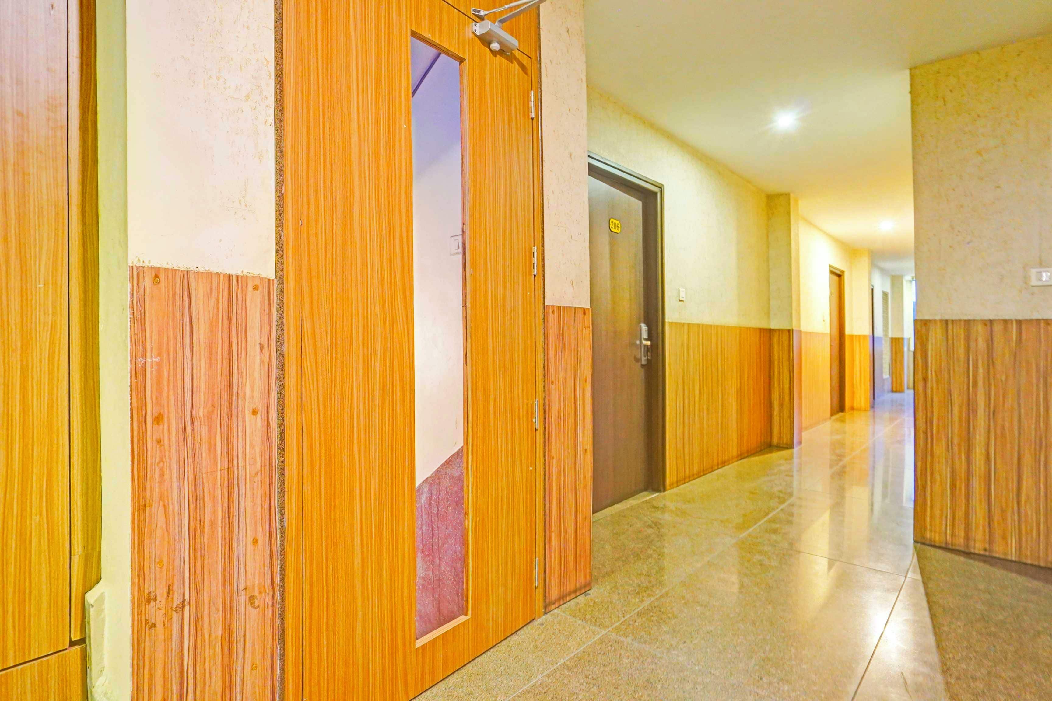 A corridor with wooden paneling and a tiled floor, leading to a door marked with the number 206.