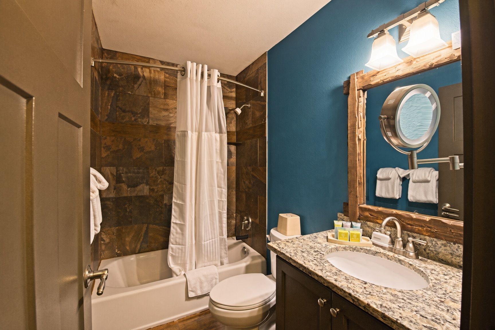 Une salle de bain avec une baignoire, des toilettes, un lavabo et un miroir.