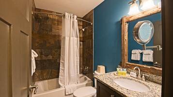 Une salle de bain avec une baignoire, des toilettes, un lavabo et un miroir.