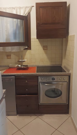 A compact kitchen with a built-in oven, a dishwasher, and a sink. - A Splendid Home at Olbia (Olbia)