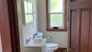 Un baño con inodoro, lavamanos y ventana.