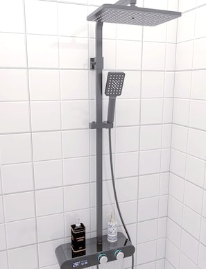 Una ducha moderna con cabezal de ducha manual y otro fijo en el techo, ambos montados sobre una estructura gris.