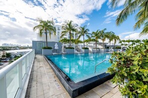 A rooftop swimming pool with palm trees, a city view, and a clear sky. - 15th Floor 2BR, W Residences: Ocean & Intracoastal Views (Fort Lauderdale)