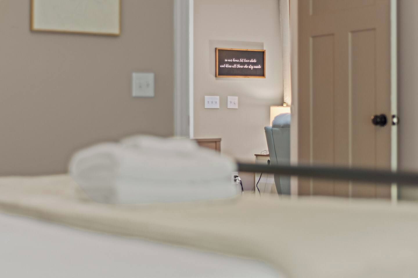 Una habitación de hotel con una cama, una mesita de noche, una silla y una puerta.