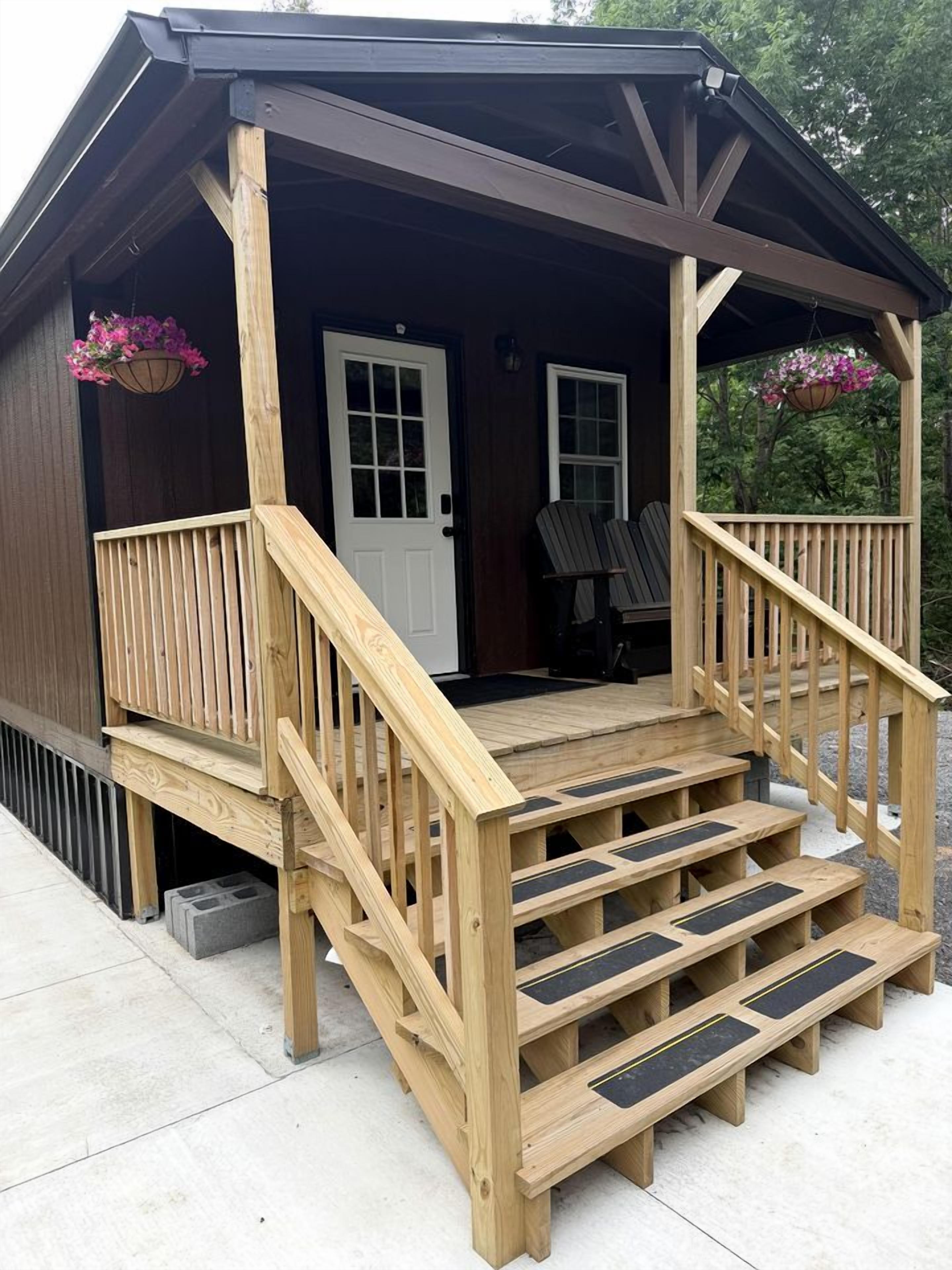 A wooden deck with a staircase leading to a covered porch.