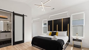 Een moderne slaapkamer met een bed, nachtkastjes en een kledingkast.