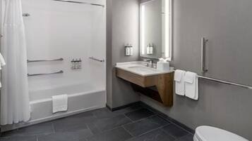 Un baño moderno con bañera, ducha, tocador e inodoro.
