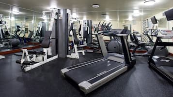 Een sportschool met loopbanden, krachtapparaten en fitnessballen.