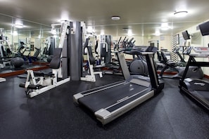 A gym with treadmills, weight machines, and exercise balls.