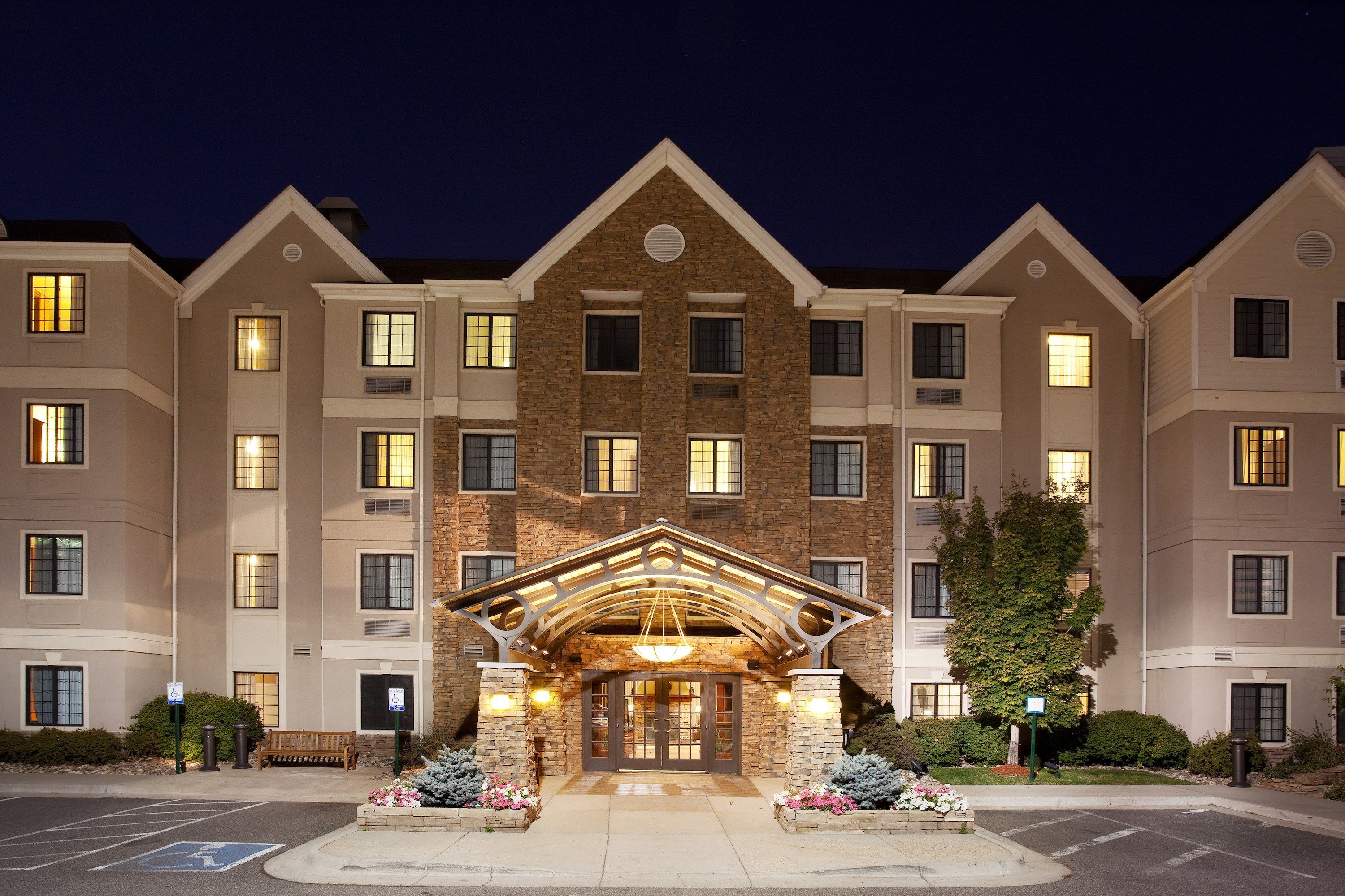 A multi-story hotel with a prominent entrance featuring a wooden archway and a central light fixture.
