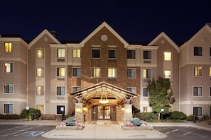 A multi-story hotel with a prominent entrance featuring a wooden archway and a central light fixture.