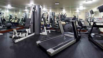 A gym with treadmills, weight machines, and exercise balls.