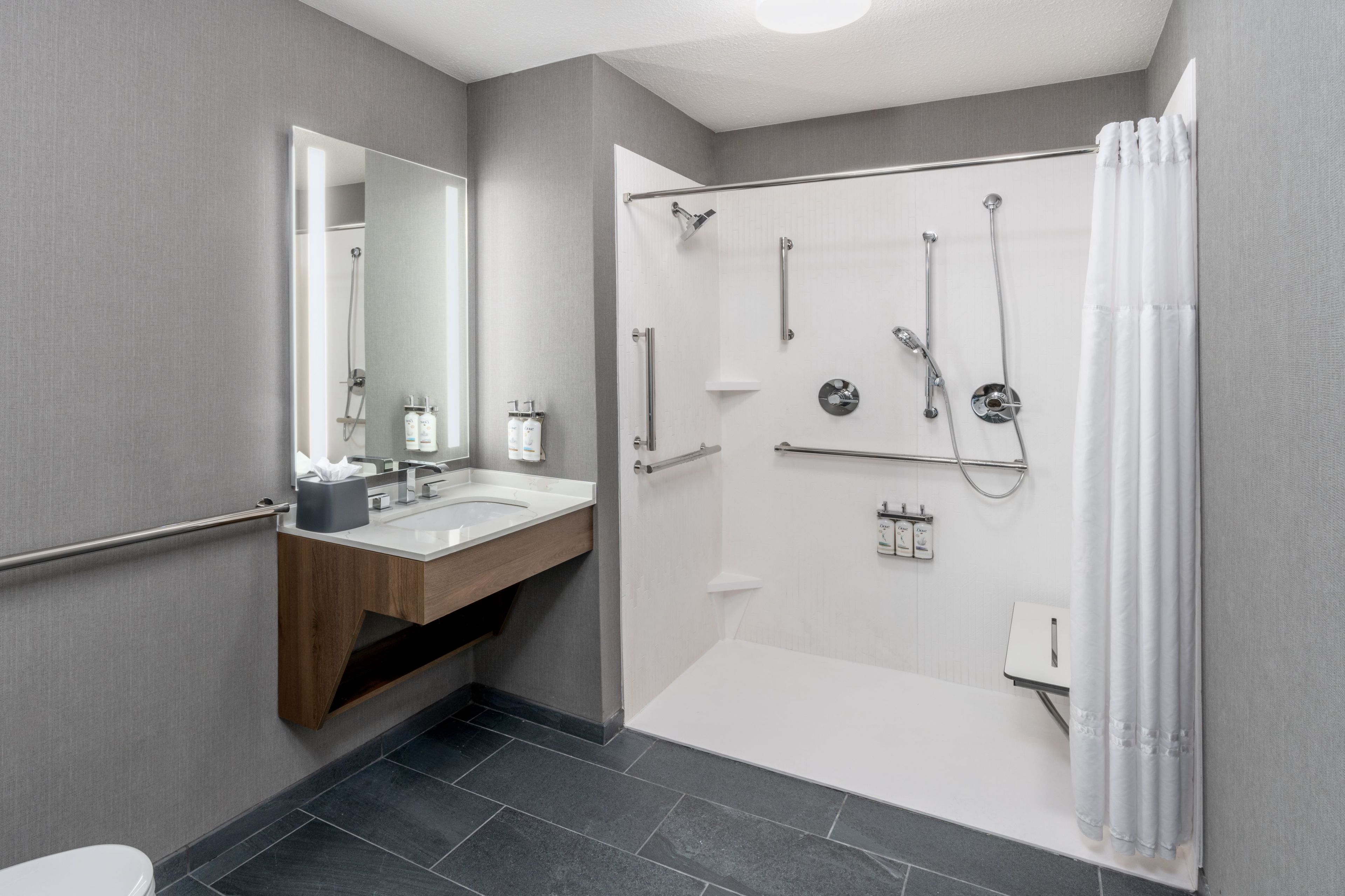 Un baño moderno con ducha, inodoro y tocador.