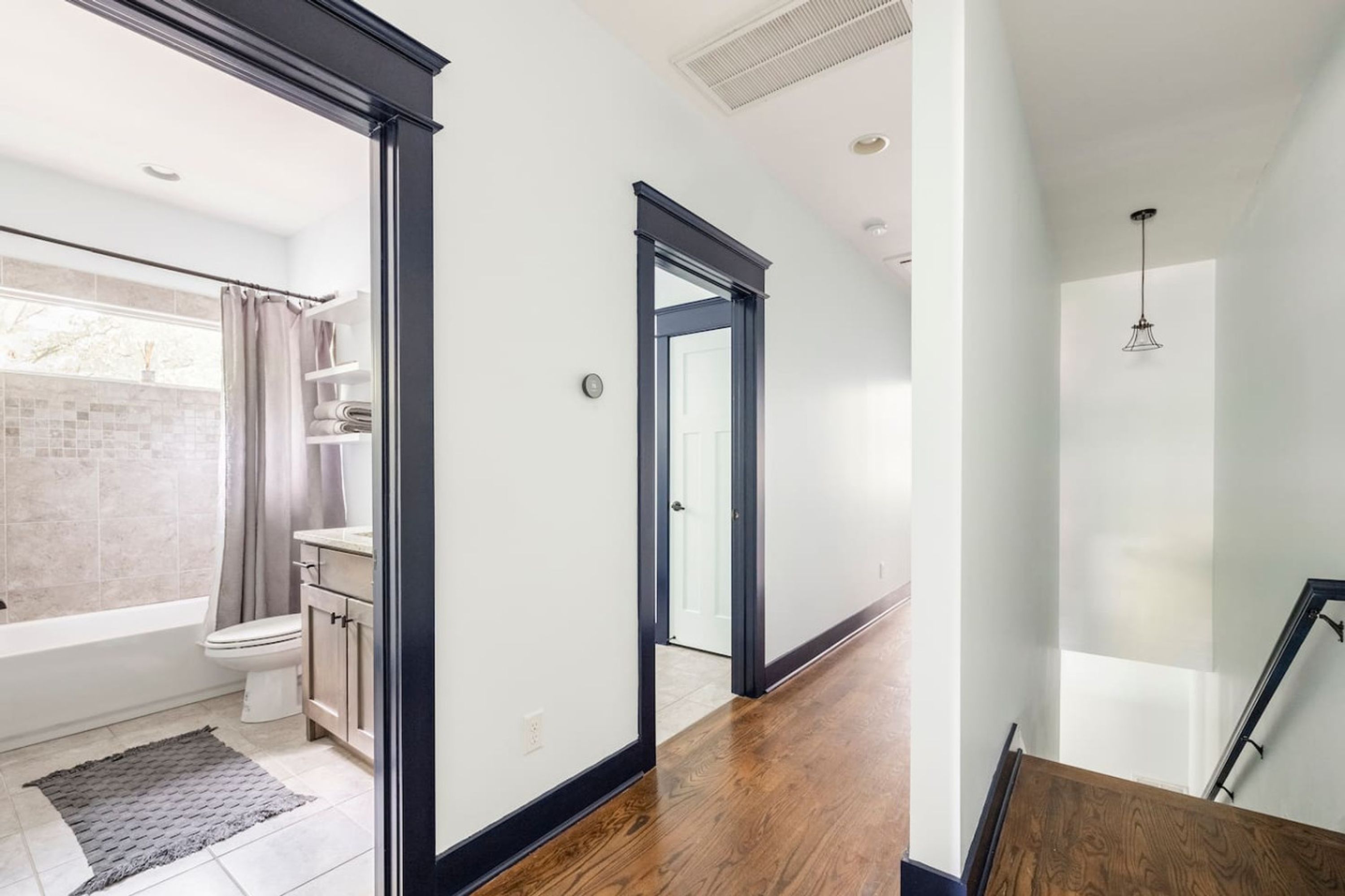 A modern bathroom with a bathtub, toilet, and shower area.