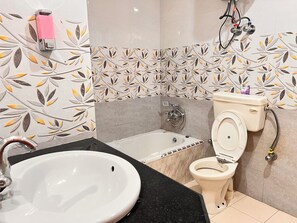 Casa de banho com lavatório branco, banheira e sanita.